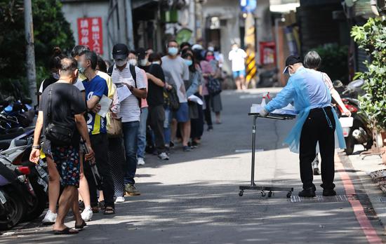  台湾居民在核酸筛检站外排队等候